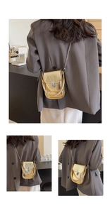 Detailed view of the gold metallic shoulder bag with silver chain strap and top handle