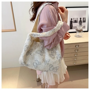 Detail of white chiffon tote bag with fuzzy butterfly patterns and wide shoulder strap