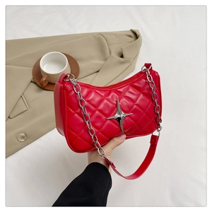 Detail of red quilted shoulder bag with silver star ornament and chain strap