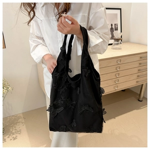 Detail of elegant black lace canvas tote bag with 3D butterfly floral embroidery