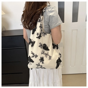 Detailed embroidery view of black butterfly patterns on white chiffon bucket bag