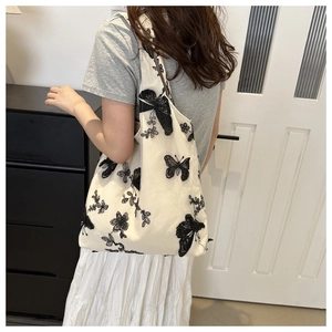 Detailed embroidery of black butterflies on a chic cream chiffon tote bag for women