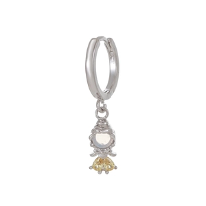 Close-up of silver drop earrings featuring a cartoon character with yellow heart crystals