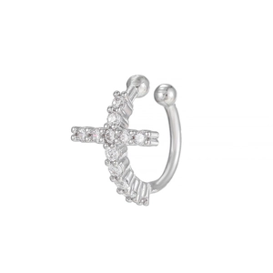 Macro shot of silver C-shaped ear cuff featuring a cross set with shimmering gemstones