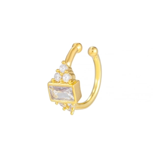 Détail macro d'un earcuff doré orné de zircons rectangulaires et ronds scintillants