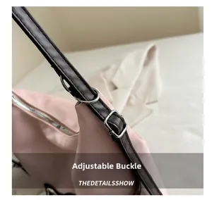 Détail de la boucle de réglage en métal argenté sur la bandoulière d'un sac rose