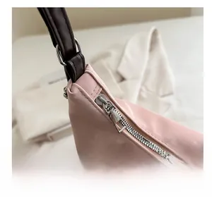 Gros plan sur la fermeture éclair lisse et les coutures du sac bandoulière rose