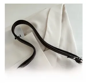 Détail de la bandoulière en cuir marron avec coutures fines et boucle en métal argenté