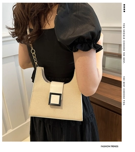 Detail of contrast stitch shoulder bag with golden chain strap and buckle decoration