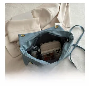 Internal view of blue denim shoulder bag showing spacious storage for daily essentials