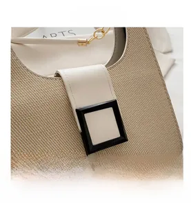 Detail of woven straw and white leather patchwork with a gold chain strap and square buckle