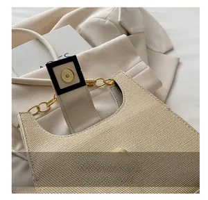 Close-up of magnetic buckle closure and woven texture on beige shoulder bag