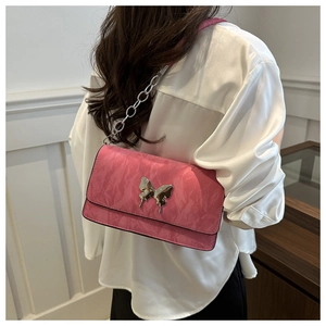 Pink shoulder bag detail with silver butterfly ornament and stylish chain strap