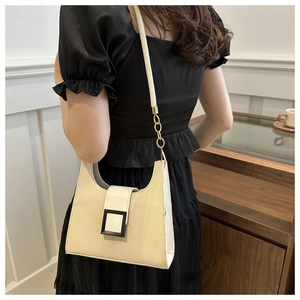 Close-up of beige woven texture shoulder bag with leather trim and black buckle detail