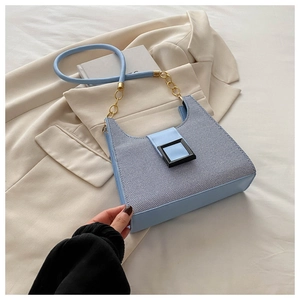 Close-up of light blue woven underarm bag with black buckle and gold chain strap detail
