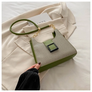 Detail of green leather and beige woven fabric underarm bag with gold chain strap