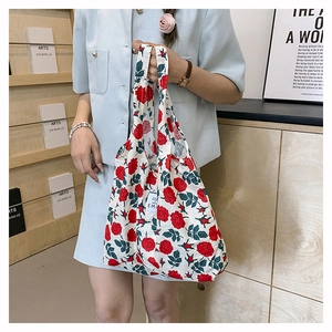 Detalle de bolso tote blanco de gran capacidad con elegante estampado de rosas rojas