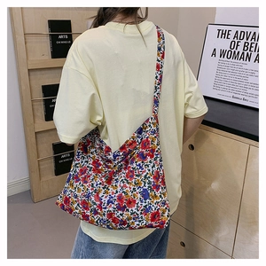 Rear view of a model wearing the vibrant floral nylon crossbody bag in a studio setting