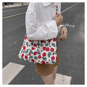 Close-up of lightweight nylon shoulder bag featuring vibrant red rose floral patterns