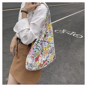 Foto callejera de una gran bolsa de compras de nailon con estampados florales coloridos