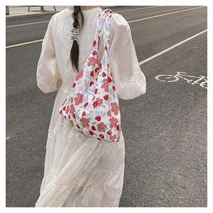 Detalle de bolsa de compras ligera de nailon con estampado floral y etiqueta tejida