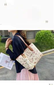 Detail of off-white graffiti tote bag with brown straps and a cute plush bunny charm