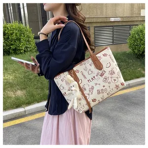 Chic tote bag with American graffiti prints and brown leather handles in outdoor setting