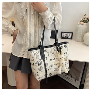 White leather tote bag with black graffiti prints and cute bunny plush charm accessory