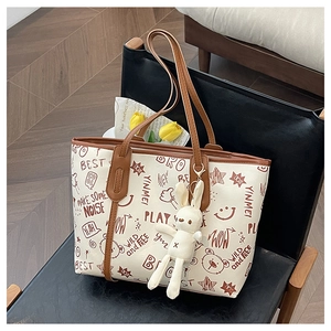 Contrast tote bag with brown straps, graffiti prints, and a cute bunny pendant