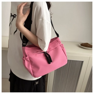 Detail van roze nylon crossbodytas met verstelbare brede band en trekkoorddetails