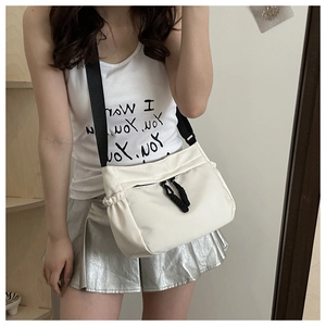 Detail van witte nylon crossbodytas met verstelbare zwarte brede band en ritszakje