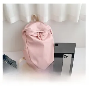 Pink nylon backpack detail showing spacious interior with tablet and phone