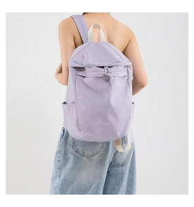 Rear view of a lavender nylon drawstring backpack showing the side pocket and white handle
