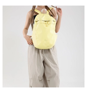 Pale yellow nylon backpack featuring large capacity compartments and front zipper pocket
