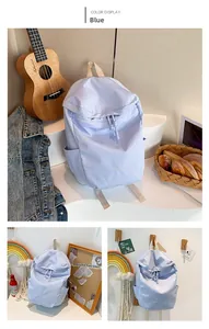 Detail view of the lilac nylon backpack showing front pocket and minimalist Bag embroidery