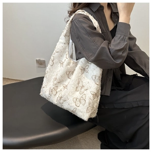 Detail of embroidered butterfly chiffon bag with raw fringe edges and soft texture