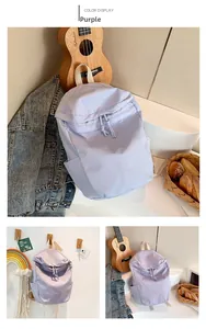 Detail of light purple nylon backpack featuring drawstring closure and side pockets