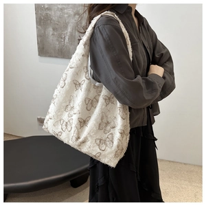 Detailed shot of white chiffon tote bag with butterfly embroidery and fringe texture