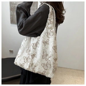 Detail of floral chiffon tote bag featuring brown butterfly embroidery and textured fabric
