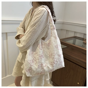Frayed fabric shoulder bag featuring pink butterfly patterns and soft texture