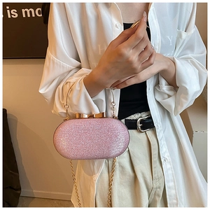 Détail d'une pochette de soirée rose pailletée avec poignée dorée et fermoir nœud