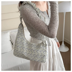 Détail du sac bandoulière en toile fleurie avec bandoulière à volants et fermeture