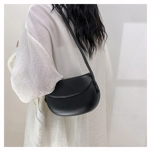 Minimalist black crescent saddle bag shown on model for daily commuting style