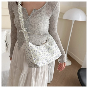 Detail of floral hobo bag with pleated shoulder strap and vintage flower pattern