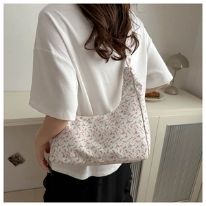 Floral hobo shoulder bag with pink blossom patterns shown on model in cozy interior
