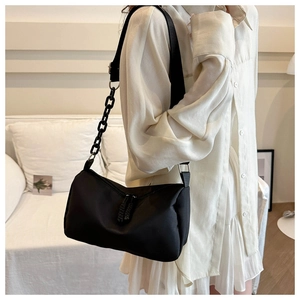 Détail du sac bandoulière en nylon noir avec chaîne épaisse et large bandoulière en tissu