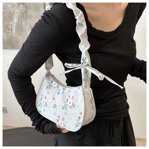 Detailed view of floral hobo bag with ruffled shoulder strap and bow decoration