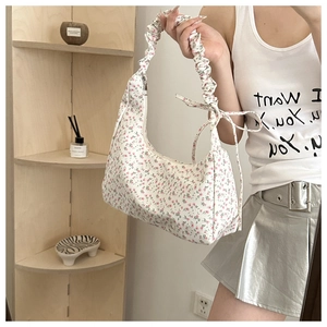 Close-up of floral hobo bag with pleated shoulder strap and decorative bow detail
