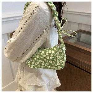 Detail of green floral hobo bag with adjustable ruched strap and metallic zipper closure