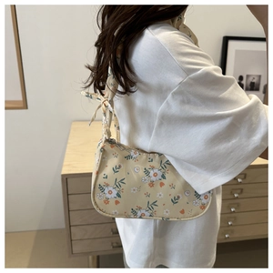 Detailed close-up of a large floral shoulder bag with delicate yellow floral patterns